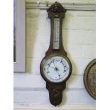 An Edwardian stained oak banjo barometer, with foliate carving, mercury thermometer and aneroid