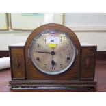 A 1920s oak mantel clock, the arched case with silvered dial, the three train movement striking on a