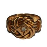 An 18 carat gold knot ring with central diamond