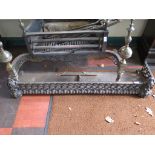 A Victorian cast iron fire fender, of repeating scroll design 122cm wide, a wrought iron fire screen