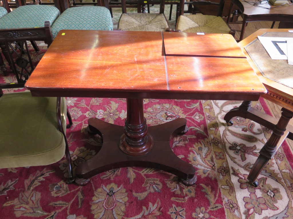 A Victorian mahogany reading table, the sliding adjustable top with two reading slopes on a turned