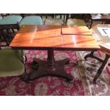 A Victorian mahogany reading table, the sliding adjustable top with two reading slopes on a turned