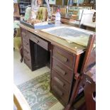 An oak kneehole desk, the central drawer over cupboard doors to the kneehole flanked by four drawers