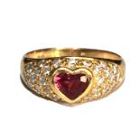 An 18 carat gold ring set with diamonds and a heart shaped red stone (possibly ruby)