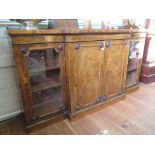 An early Victorian burr walnut breakfront side cabinet or credenza, the brass gallery over a pair of