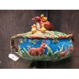 A Majolica pie dish in the style of George Jones, the quail and chicks lid over a rabbit decorated