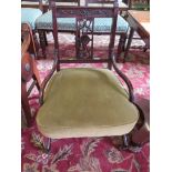 A pair of Edwardian mahogany bedroom chairs, with floral carved rectangular backs and sabre legs