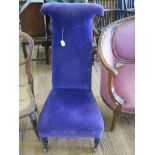 A Victorian ebonised Prie Dieu chair, with purple upholstery and turned legs on brass castors, and a