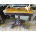 A mid Victorian rosewood foldover card table, with cabochon carved baluster stem on a platform