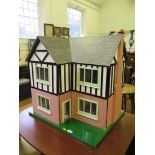 A large painted wood and papered dolls house with two opening front sections and four carpeted