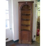 A Georgian style pine display cabinet, with three shaped open shelves in an alcove over a cupboard