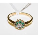 An emerald and diamond cluster ring set in 18 carat yellow gold
