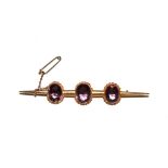 An Edwardian bar brooch set with three amethyst stones