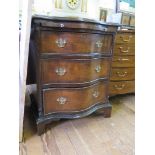 A George III style walnut serpentine chest with brushslide three long graduated drawers, blind