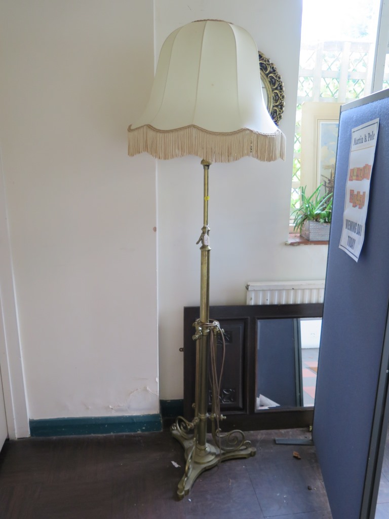 An Edwardian brass adjustable standard lamp, on a scrolling tripod base