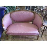 A Louis XVI style settee, with pink upholstery, oval back and downswept sides carved with flowers