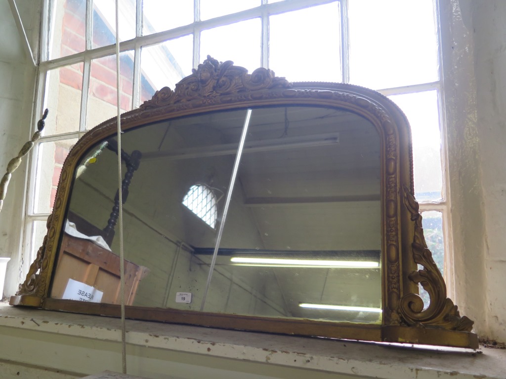 A Victorian giltwood overmantel mirror, with mask over an arched plate within an egg and scroll