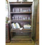 A stained oak Globe Wernicke stacking bookcase, the four sections with glazed fall fronts over a