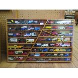 Seventy Lledo and Models of Yesteryear advertising vans in a wood and perspex wall cabinet