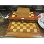 An old chessboard together with a set of chess pieces and a cased backgammon and chess set