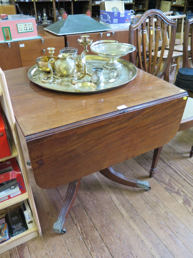 A George IV style mahogany dropleaf table, with ring turned stem on a reeded quadruped base with