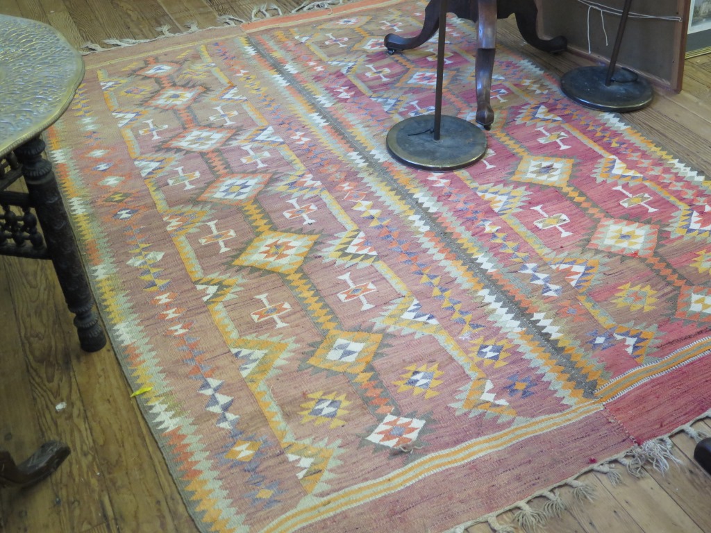 A Kilim rug, formed in two parts, with diamond decoration on a red field 238cm x 162cm