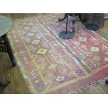 A Kilim rug, formed in two parts, with diamond decoration on a red field 238cm x 162cm