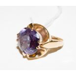 A gold colour metal ring, set with a large round amethyst