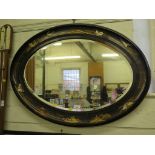 A 1920s oval wall mirror, the bevelled plate within a chinoserie frame, 65cm x 91cm