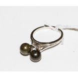 A white gold colour metal ring, set with two cultured black pearls