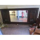 An Art Nouveau style stained oak wall mirror, with rectangular bevelled plate and floral carved