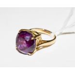 A gold colour metal ring, set with a man made alexandrite