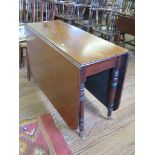 An early Victorian mahogany gateleg table, with ring turned legs on pot castors 107cm wide