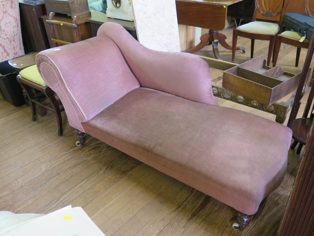 A late Victorian chaise longue with scroll carved three quarter length back and arm on fluted turned