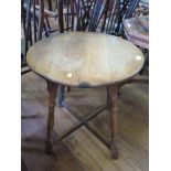 An oak occasional table, the circular top on turned legs joined by a cross stretcher, 59cm diameter