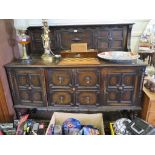 A 1920s oak panelled sideboard, with raised back over two drawers flanked by cupboard doors on