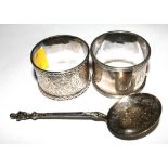 Two silver napkin rings and a silver sifter spoon by George Unite