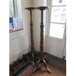 A pair of mahogany torchere stands, formerly bedposts, with foliate carving and quadruped bases,