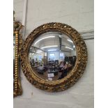A giltwood circular convex mirror with foliate pierced frame, 47cm diameter