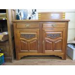 An Edwardian walnut sideboard, with two drawers over a pair of carved cupboard doors on bracket