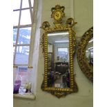 A George III style giltwood mirror, the rectangular plate within foliate scrolls surmounted by a