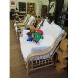 A cane conservatory suite comprising a two seat settee, two armchairs, two side tables and a