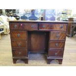 A reproduction mahogany kneehole desk, the leather inset top over two frieze drawers, above a