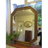 A canted rectangular giltwood wall mirror with vine leaf decorated frame, 87cm x 68cm
