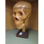 A carved wood model of a skull, with hinged crown and jaw, 28cm high