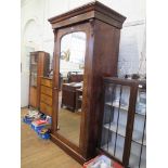 A mid Victorian mahogany wardrobe, the moulded cornice with corbels over a mirrored door on plinth