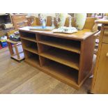 A pine side cabinet with raised back above open bookshelves, 127cm wide, 86cm high