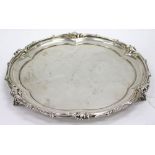 A BIRMINGHAM SILVER SALVER on three foliate feet with decorated border and engraved reverse, dated