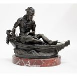 A BRONZE SCULPTURE OF A NATIVE AMERICAN INDIAN in a canoe, mounted on an oval marble base, 38cm wide