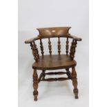 AN OLD SMOKERS BOW ARM CHAIR with turned supports, 64cm wide